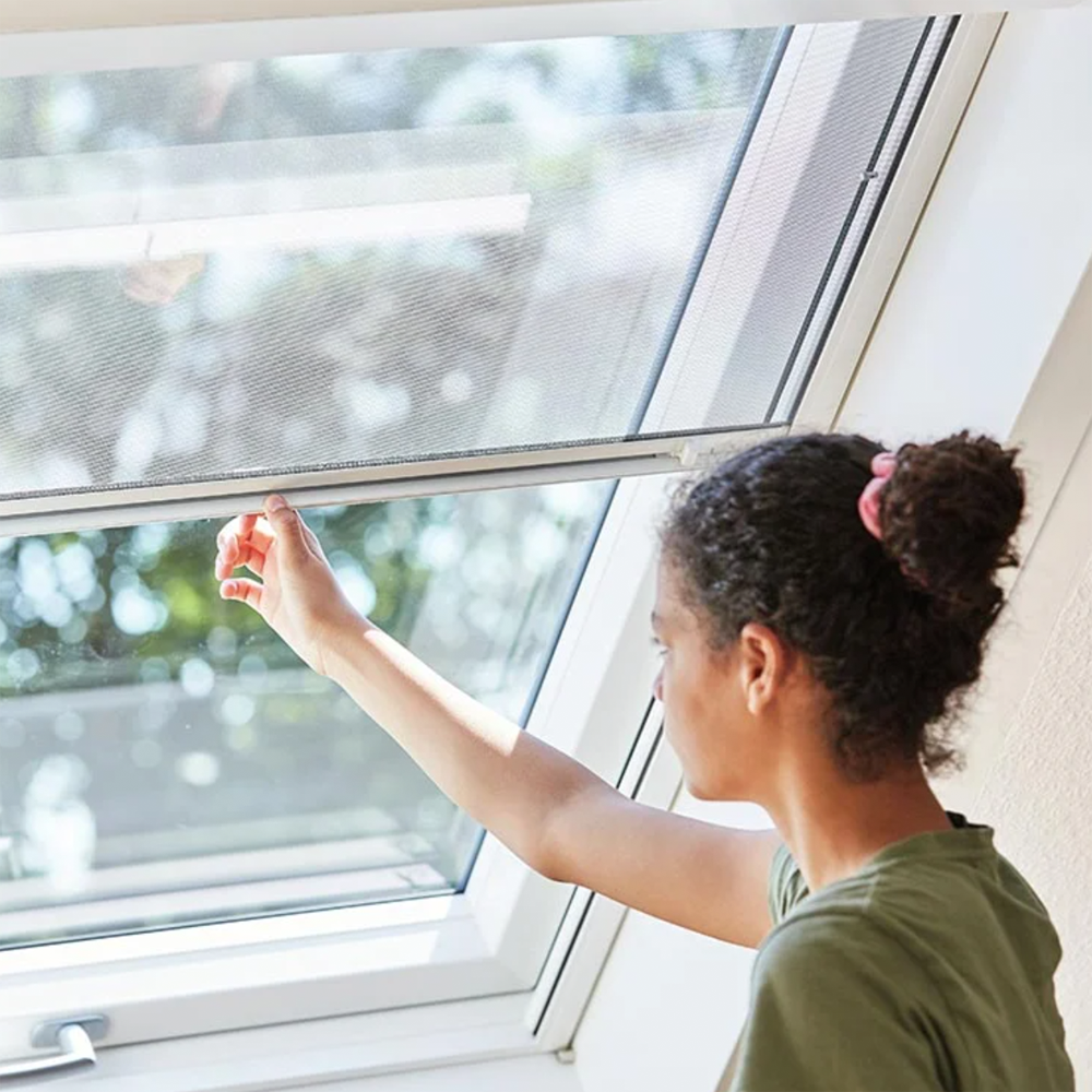 Roto-Dachfenster: Zubehör
Bild zeigt eine Frau, mit dunklen Haaren und grünem T-Shirt, die ein Insekteschutzrollo an einem Roto-Dachfenster schließt. 