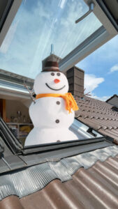 alt="Sommeraktion: Schneemann im Dachfenster"